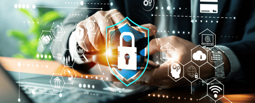 A person working on a laptop surrounded by digital cybersecurity icons, including a central glowing shield with a padlock.